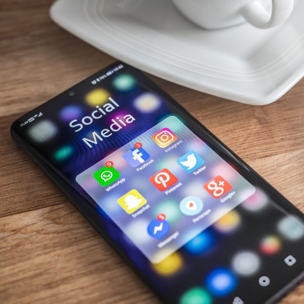 Ein Smartphone, auf dem verschiedene Social Media Plattformen als App angezeigt werden, um zu verdeutlichen, welche Plattform für die jeweilige Zielgruppe am besten ist. 